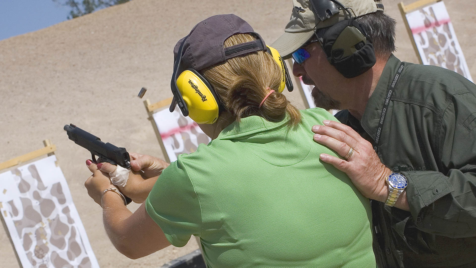 Person receiving firearm training on a range with safety gear